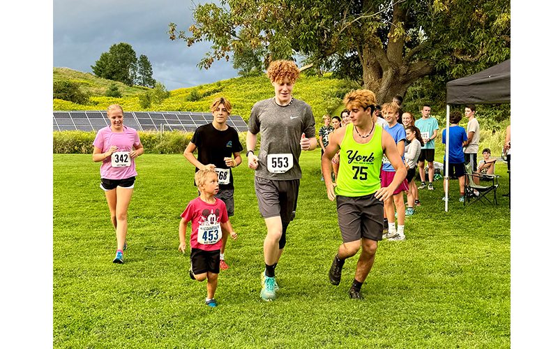 Jackson Migonis of Waterbury leads Harwood runners Alex Isham, Matteo Metcalf, Atticus Ellis, and Indy Metcalf on a victory lap at the final fun run of 2024.